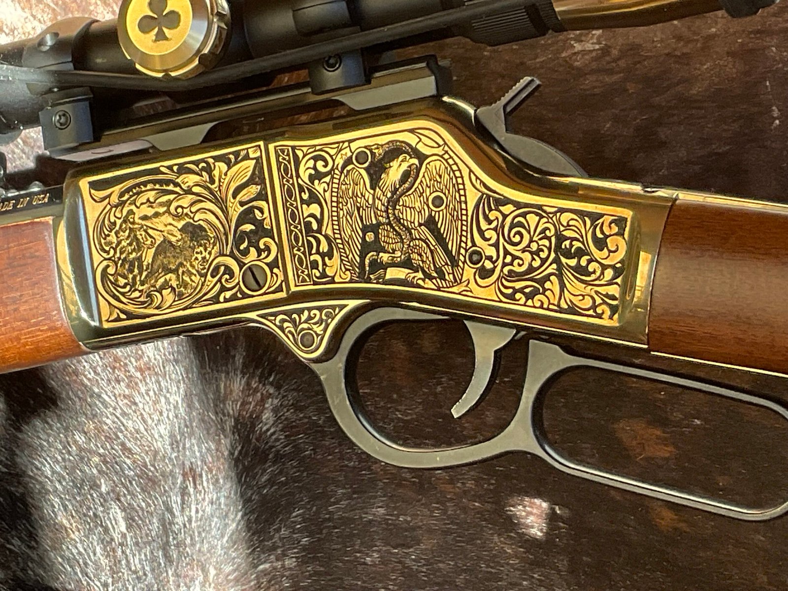 Gold and black engraved rifle receiver with scrollwork, animal scene, and eagle artwork